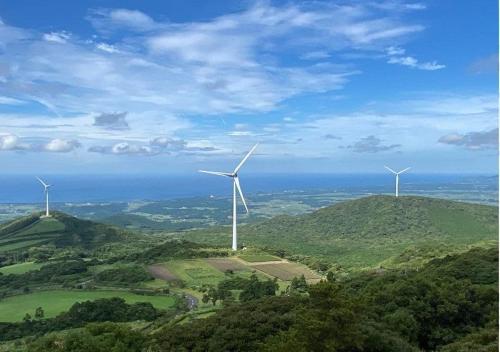two wind turbines on top of a green hill at アグリランドえい in Orio