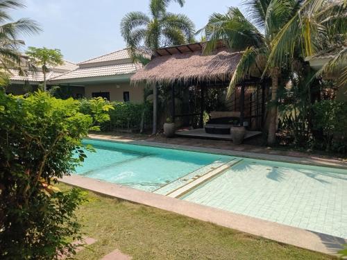 a swimming pool in front of a house at Tropical House​ in Hua Hin