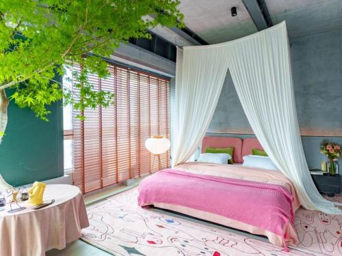 a bedroom with a pink bed with a canopy at M Panda Tower Boutique Chengdu in Chengdu