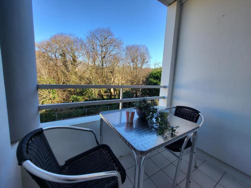 un balcon avec une table et deux chaises et une fenêtre dans l'établissement Appartement pour 2, balcon, parking, près plage – Saint Brevin l'Océan - FR-1-364-176, à Saint-Brévin-les-Pins