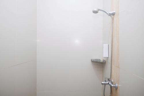 a shower with a glass door in a bathroom at Joglo Manggisan Syariah Kotagede Mitra RedDoorz in Yogyakarta