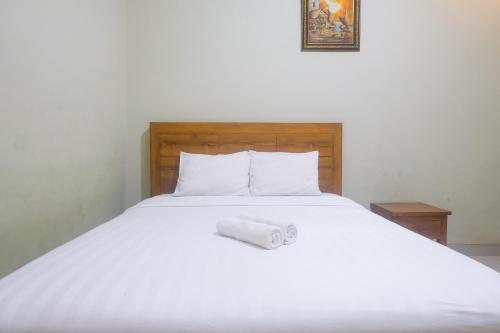 a white bed with a roll of toilet paper on it at Joglo Manggisan Syariah Kotagede Mitra RedDoorz in Yogyakarta