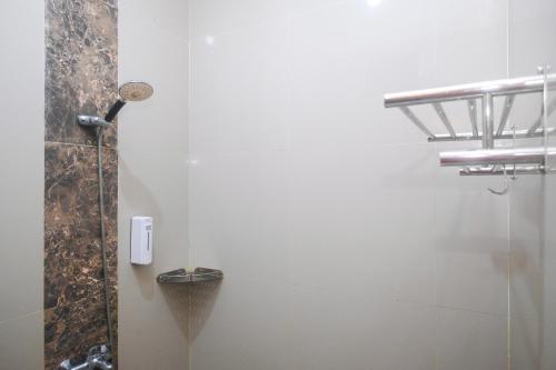 a bathroom with a shower and a phone on the wall at Joglo Manggisan Syariah Kotagede Mitra RedDoorz in Yogyakarta