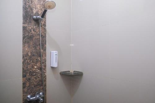a shower in a bathroom with a shower at Joglo Manggisan Syariah Kotagede Mitra RedDoorz in Yogyakarta