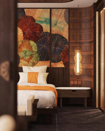 a bedroom with a bed and a painting of umbrellas at Amiana Resort Cam Ranh in Cam Ranh