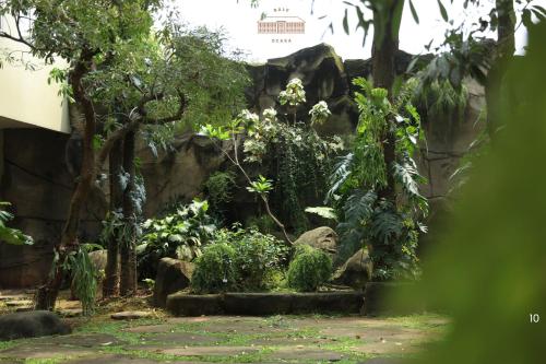 a garden in a zoo with trees and plants at Bale Ocasa by Behomy in Tangerang