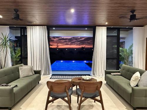 a living room with a couch and a tv at 4BR Villa with Pool in Calatagan Batangas up to 16 Guests in Calatagan
