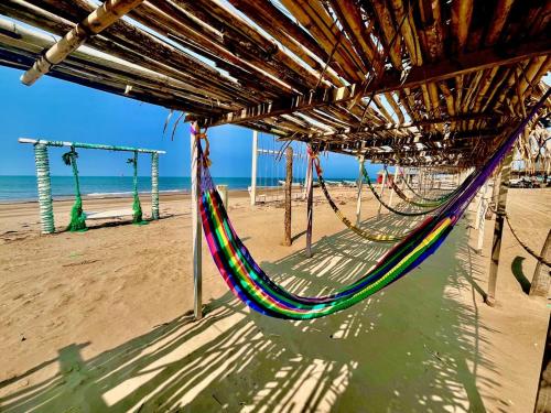 a hammock on a beach with the ocean at Casa de Playa en Antón Lizardo con alberca privada y club Playa in Heroica Alvarado