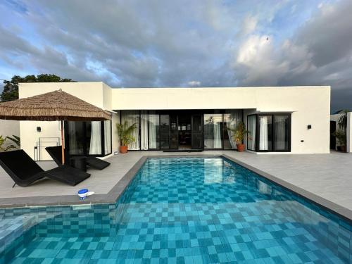a swimming pool in front of a villa at 4BR Villa with Pool in Calatagan Batangas up to 16 Guests in Calatagan