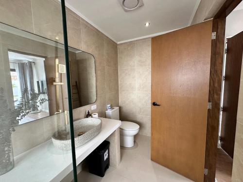 a bathroom with a sink and a toilet and a mirror at 4BR Villa with Pool in Calatagan Batangas up to 16 Guests in Calatagan