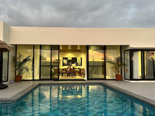a swimming pool in front of a house at 4BR Villa with Pool in Calatagan Batangas up to 16 Guests in Calatagan