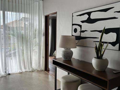 a living room with a table with a lamp and chairs at 4BR Villa with Pool in Calatagan Batangas up to 16 Guests in Calatagan