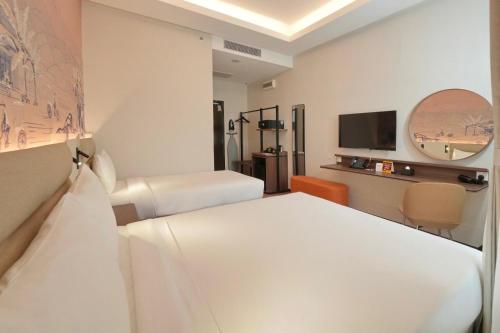 a hotel room with two beds and a tv at Cititel Express Ipoh in Ipoh