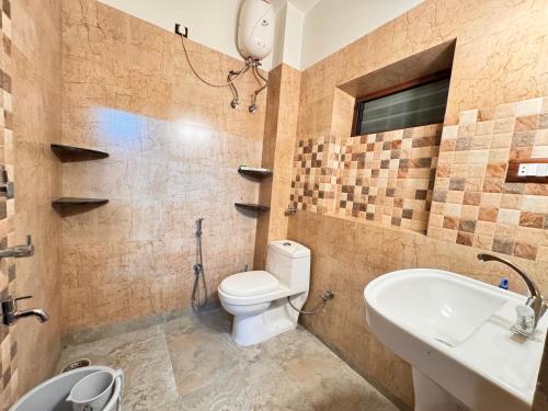 a bathroom with a toilet and a sink at BKC Apartment in Siliguri