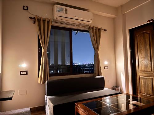 a living room with a couch and a window at BKC Apartment in Siliguri