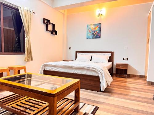 a bedroom with a bed and a coffee table at BKC Apartment in Siliguri