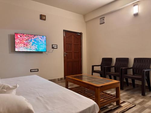 a room with a bed and a table and chairs at BKC Apartment in Siliguri