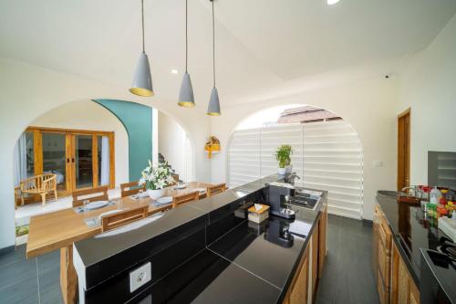 a kitchen and dining room with an archway at D'Gangga Residence By Bali Cabin in Kerobokan