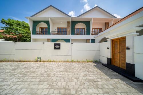 a house with a white fence and a driveway at D'Gangga Residence By Bali Cabin in Kerobokan