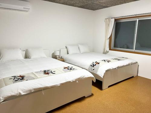 a bedroom with two beds and a window at Sunshine in Tokyo