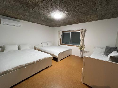 a bedroom with two beds and a window at Sunshine in Tokyo