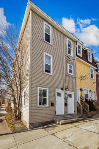 a gray house with white doors on a street at Queens Suite 1bdrm in St. John's