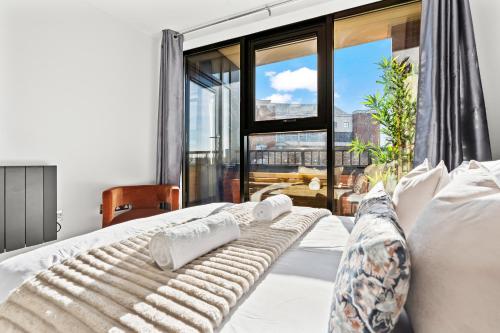 Un dormitorio con una cama y una ventana grande. en ArraeLuxe, 2 BEDROOMS 2 BATH Sleeps 5, PARKING, Central Location By Utilita Arena, ICC, Broad Street, Brindley Place and LEGOLAND, en Birmingham
