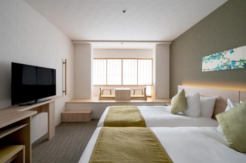 a hotel room with two beds and a flat screen tv at Hotel Vista Premio Kyoto Nagomi tei in Kyoto