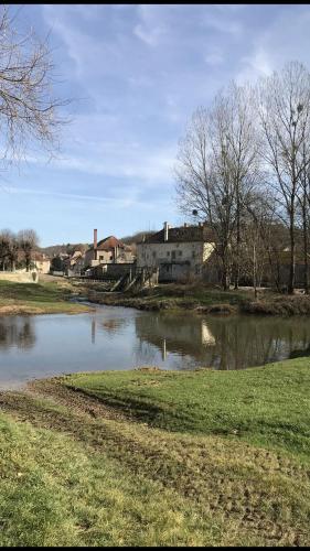 une masse d'eau avec un bâtiment en arrière-plan dans l'établissement Chez Pierre, à LʼIsle-sur-Serein
