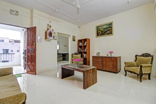 a living room with a coffee table and chairs at Hotel O Star in Kharadi