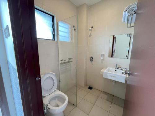 a bathroom with a toilet and a sink at Morib Prosper Resort by uBook in Banting