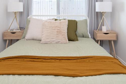 a white bed with two nightstands and two lamps at Brewers Haus - Willunga - C21 SouthCoast Holidays in Willunga