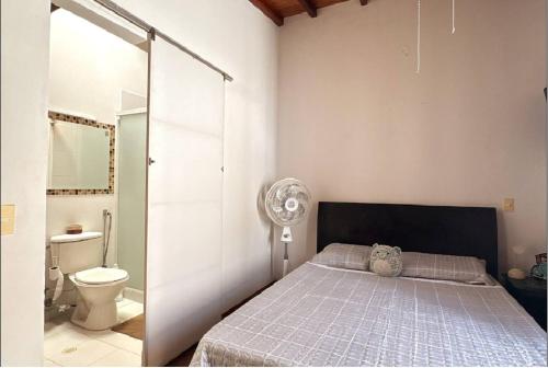 a bedroom with a bed and a bathroom with a toilet at Apto Puerta del Sol in Bucaramanga