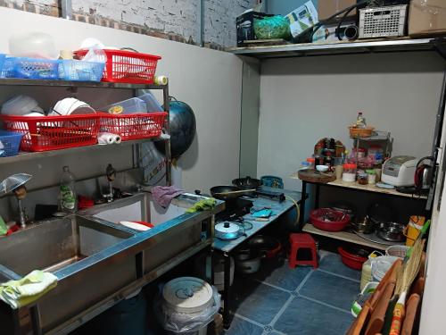 a kitchen with a sink and shelves with dishes at HangNga homestay - hotel in Phủ Từ Sơn