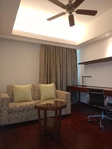 a living room with a couch and a table at Shangri-La Serviced Apartments, Yangon in Yangon