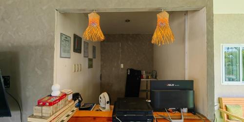 a room with a table and two lights at Green Dale's Travellers Inn Puerto Princesa in Puerto Princesa City