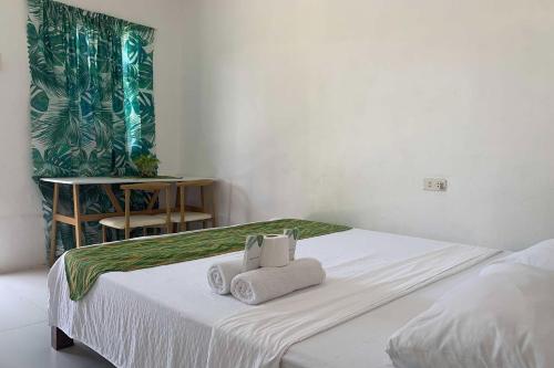 公主港Green Dale's Travellers Inn Puerto Princesa的一间卧室，床上有两条毛巾