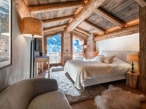 une chambre avec un lit dans une pièce avec des plafonds en bois dans l'établissement Chalet 5* pour 12 avec piscine, spa, sauna et hammam à La Clusaz - FR-1-304-307, à La Clusaz