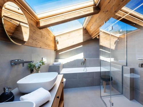 une salle de bain avec un lavabo, une baignoire et une douche dans l'établissement Chalet 5* pour 12 avec piscine, spa, sauna et hammam à La Clusaz - FR-1-304-307, à La Clusaz