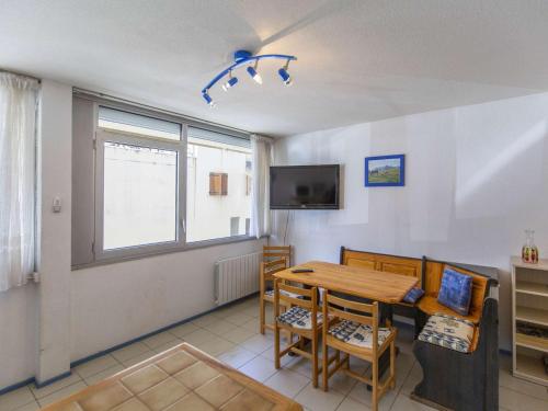 une salle à manger avec une table et une télévision dans l'établissement Studio confortable pour 4 au pied des pistes à Gourette - FR-1-400-135, à Eaux-Bonnes