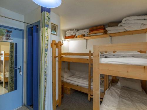 Cette chambre comprend 3 lits superposés et une porte. dans l'établissement Studio confortable pour 4 au pied des pistes à Gourette - FR-1-400-135, à Eaux-Bonnes