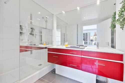 La salle de bains est pourvue de placards rouges et d'une douche en verre. dans l'établissement Appartement Quartier Tour Eiffel 7 Free Netflix, à Paris