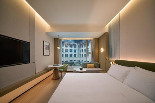 a hotel room with a bed and a television at Holiday Inn Wuhan Tianhe Airport by IHG in Wuhan