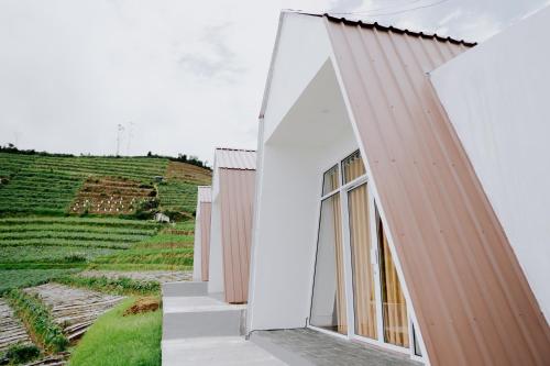 a house with a large window on the side of it at Dieng Khatulistiwa By Travelink in Diyeng