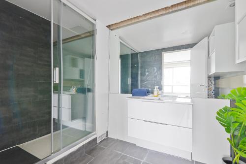 une salle de bain avec une douche en verre et un lavabo dans l'établissement Appartement Quartier Tour Eiffel 5 Free Netflix, à Paris