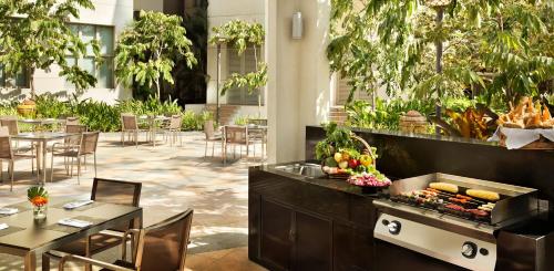 a restaurant with tables and chairs and a grill with food at Shangri-La Serviced Apartments, Yangon in Yangon