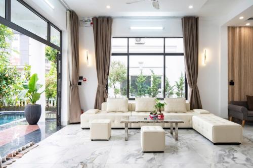 a living room with white furniture and a pool at DELUXE VILLA 2 có 5 phòng ngủ trung tâm tp in Thôn Trường Giang
