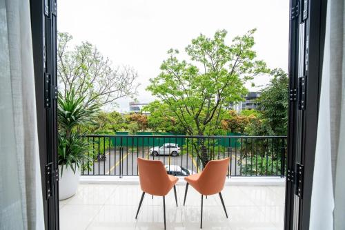 a balcony with two chairs and a table at DELUXE VILLA 2 có 5 phòng ngủ trung tâm tp in Thôn Trường Giang