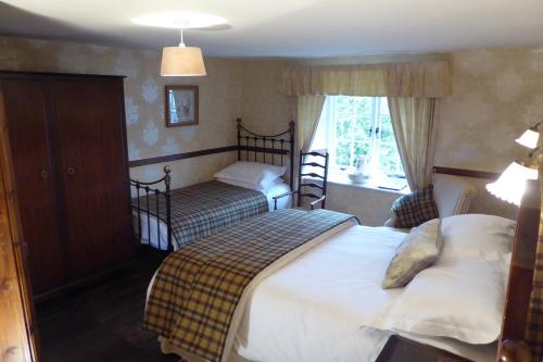 um quarto com 2 camas e uma janela em High Wray Farm em Ambleside