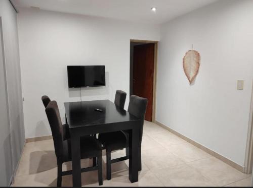 a dining room with a black table and chairs at Enjoy Apart Campana in Campana